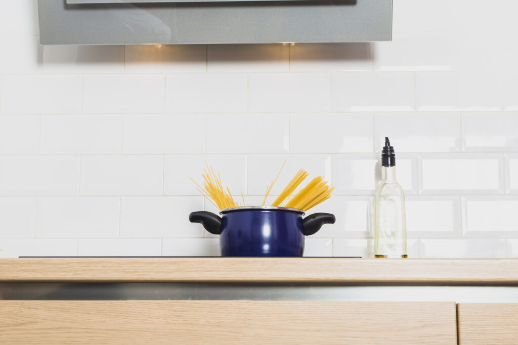 Close-up of white beveled subway tile backsplash behind a kitchen cooktop.