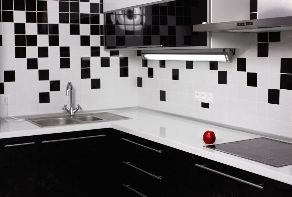 Black and white square mosaic tile backsplash in a modern monochromatic kitchen.